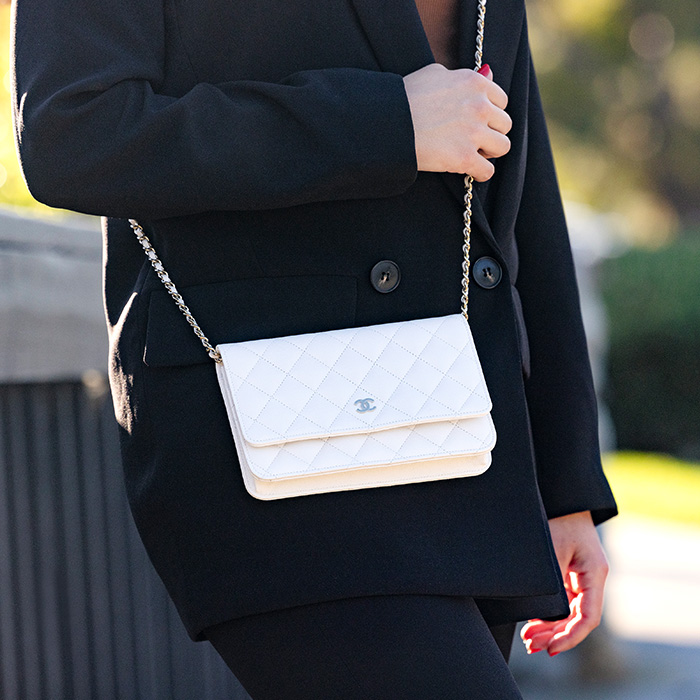 lifestyle image of model wearing the chanel wallet on chain (woc) as a crossbody FASHIONPHILE